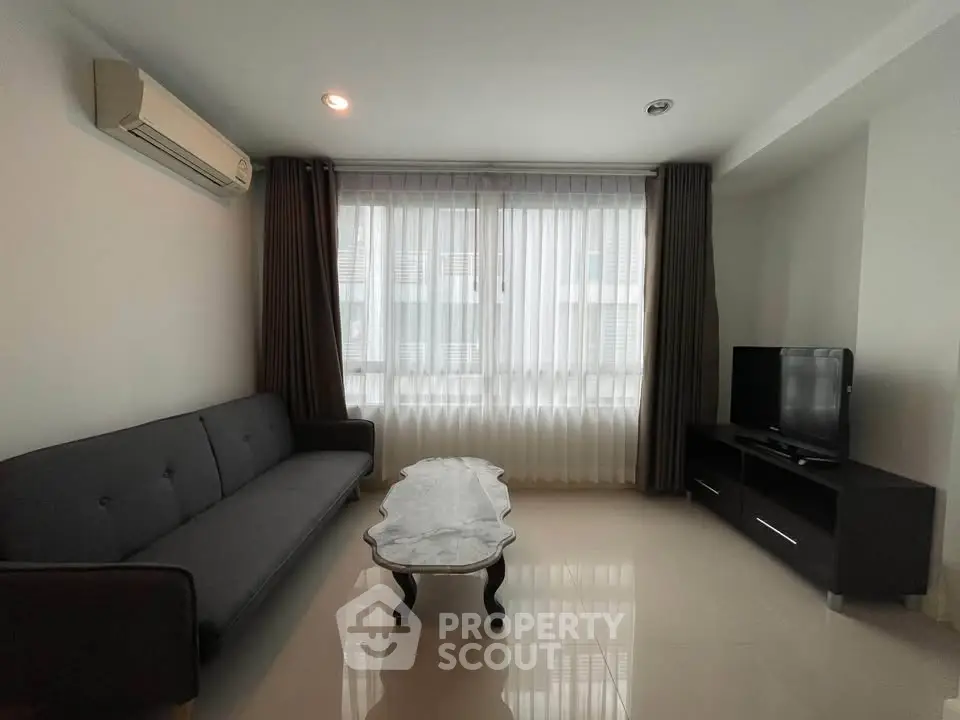 Modern living room with sleek furniture and large window for natural light.