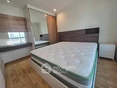 Modern bedroom with large bed and mirrored wardrobe in a stylish apartment.