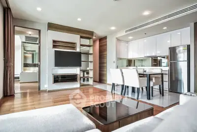 Modern open-plan living room with sleek kitchen and dining area, featuring contemporary furniture and stylish decor.