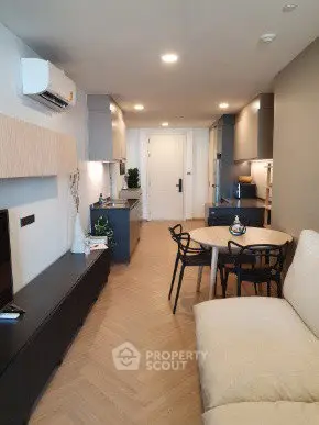 Modern living room with sleek furniture and open kitchen layout in a stylish apartment.