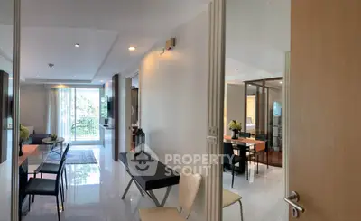 Spacious modern living room with open layout and elegant dining area, featuring large windows and stylish decor.