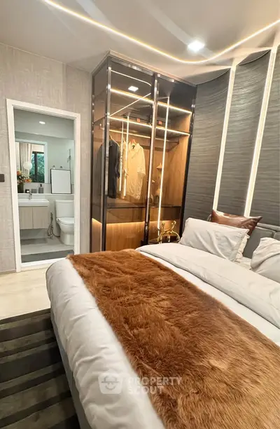 Luxurious bedroom with modern design and walk-in closet, featuring elegant lighting and plush bedding.