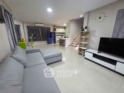 Spacious modern living room with sleek furniture and open kitchen layout