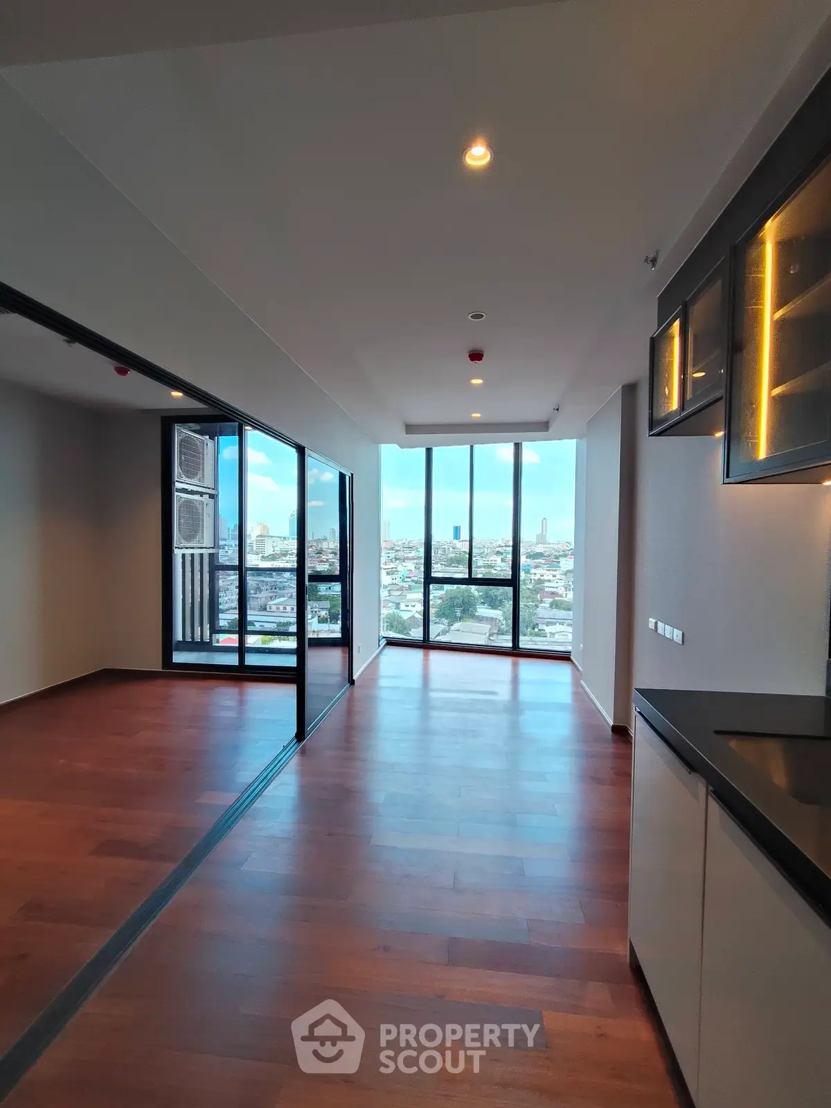 Spacious modern apartment with stunning city view and elegant wooden flooring.