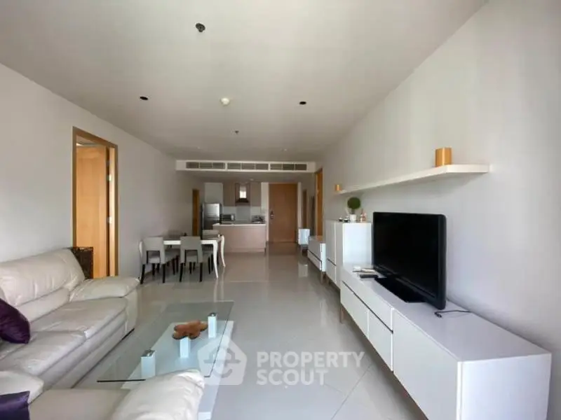 Spacious modern living room with sleek furniture and open kitchen layout in a stylish apartment.