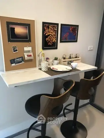 Stylish kitchen nook with bar stools and wall art, perfect for cozy dining.
