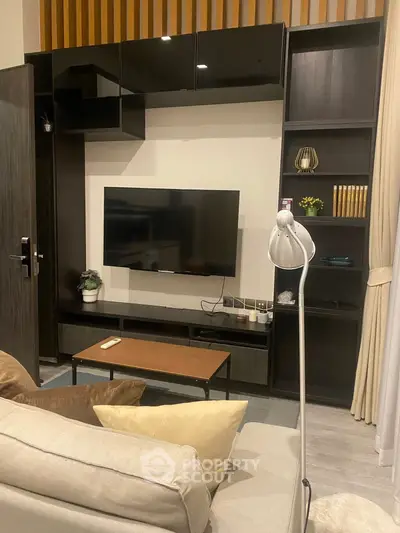 Modern living room with sleek black entertainment unit and cozy seating area.