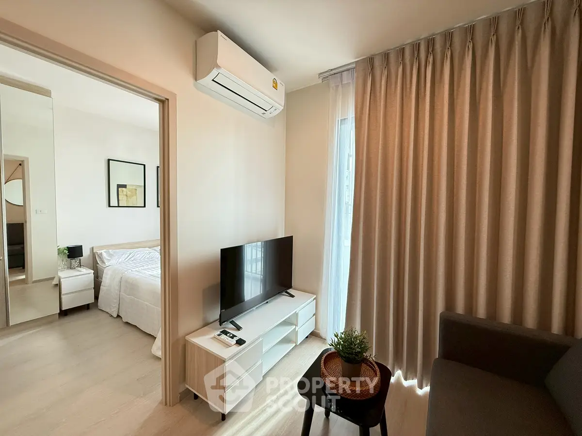 Cozy living room with modern decor and natural light, adjacent to a stylish bedroom.