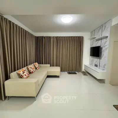 Spacious modern living room with elegant curtains and sleek TV setup.