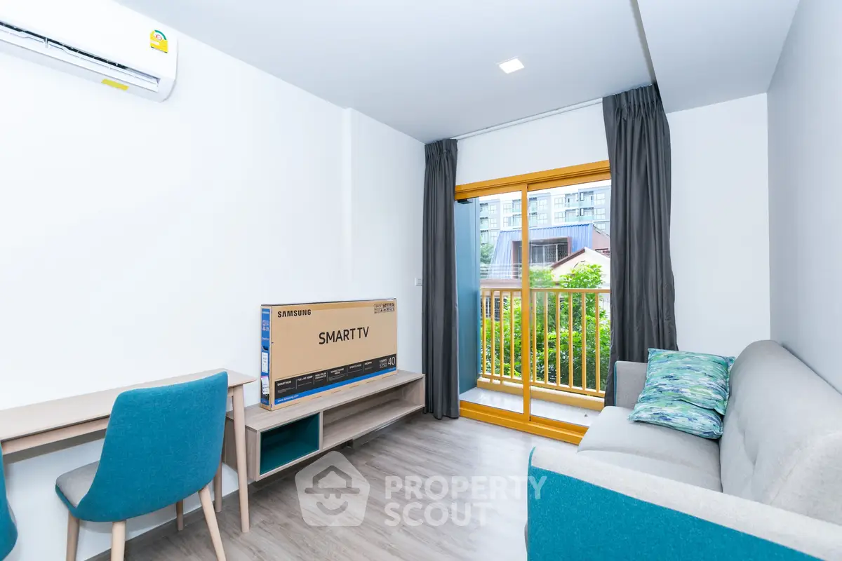 Modern living room with balcony view, featuring sleek furniture and a new Smart TV, perfect for urban living.