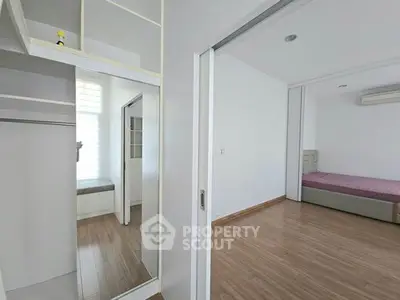 Spacious modern bedroom with wooden flooring and built-in closet