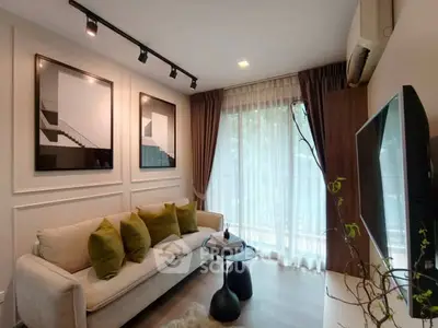 Stylish living room with modern decor and large window for natural light.
