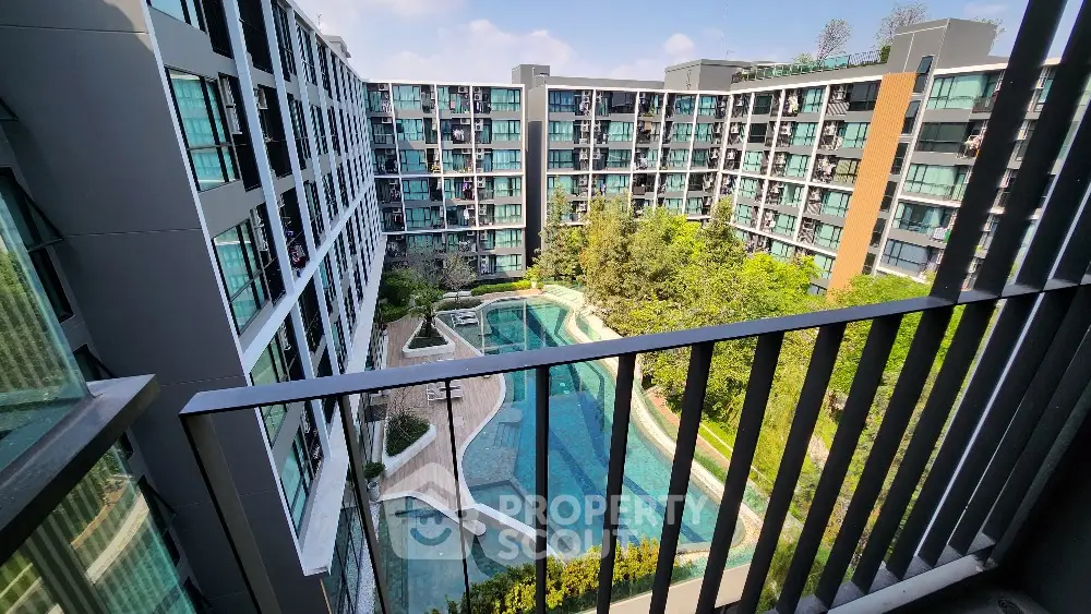 Modern condominium with pool view from balcony, showcasing urban living with lush greenery.