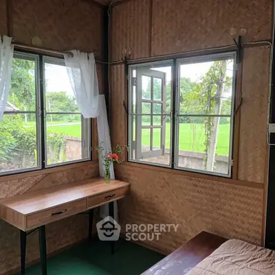 Charming rustic bedroom with woven walls and scenic window views of lush greenery.