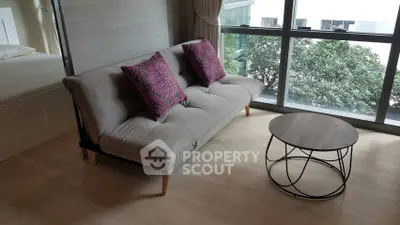 Modern living room with stylish sofa and coffee table near large window