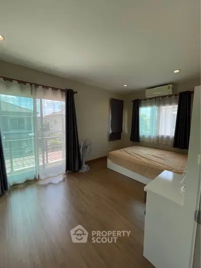 Spacious bedroom with balcony access and natural light