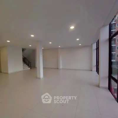 Spacious open-plan interior with large windows and modern lighting