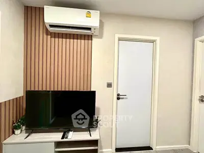 Modern living room with air conditioning and sleek TV setup, featuring stylish wood paneling and neutral tones.
