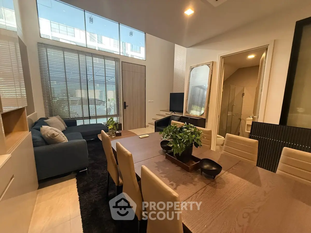 Modern living and dining area with stylish furniture and large windows