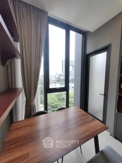 Modern study room with large window offering city view and natural light.