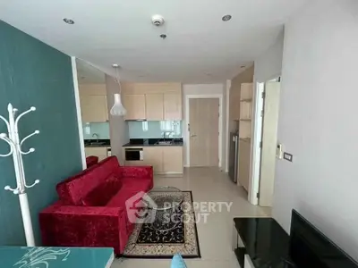 Modern living room with red velvet sofa and open kitchen layout