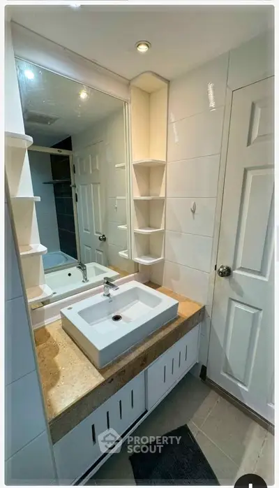 Modern bathroom with sleek sink and ample storage in a stylish home.