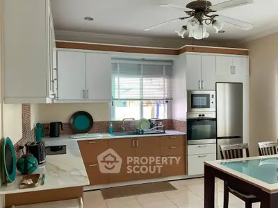 Modern kitchen with sleek cabinetry, stainless steel appliances, and a stylish ceiling fan.
