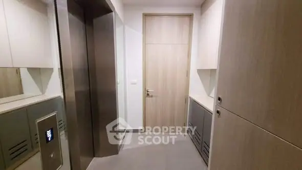 Modern apartment elevator lobby with sleek design and wooden accents.