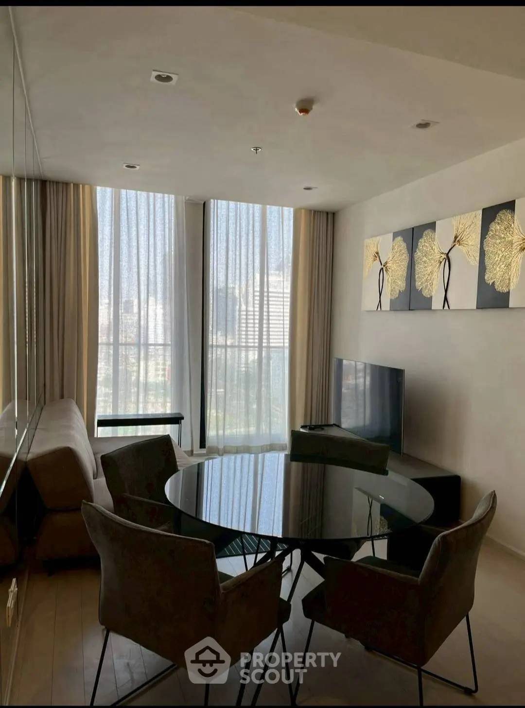 Modern living room with stylish decor and large windows offering city views.