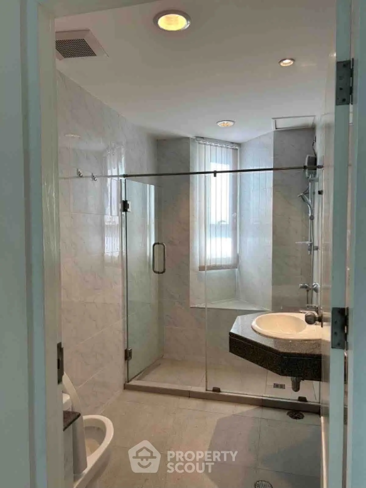 Modern bathroom with glass shower enclosure and sleek fixtures in a bright, well-lit space.