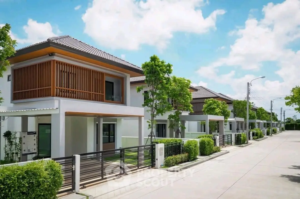 Modern suburban homes with lush greenery and clear blue skies.