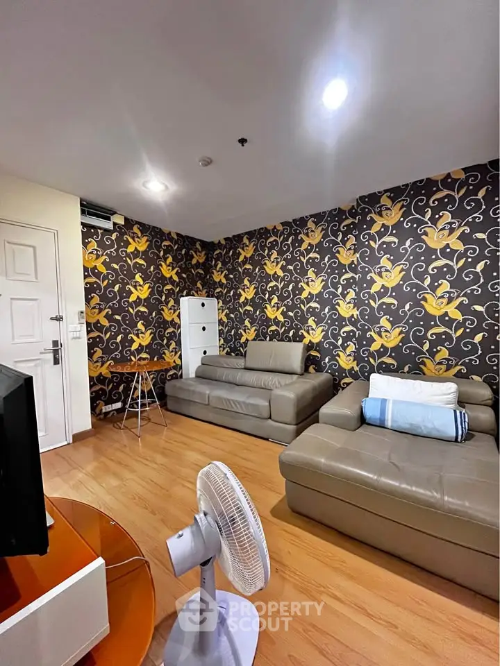 Stylish living room with modern leather sofas and vibrant wallpaper, perfect for relaxation and entertainment.