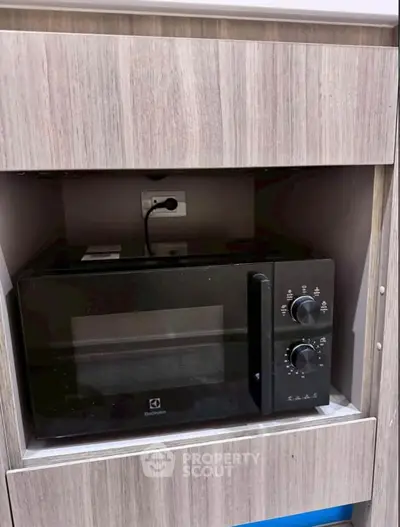 Modern kitchen with built-in microwave in sleek wooden cabinetry.