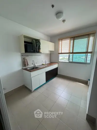Bright kitchen with large window and modern cabinetry, offering a stunning view.