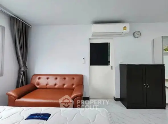 Modern living room with brown leather sofa and air conditioning unit