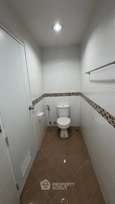 Modern bathroom with sleek white tiles and brown accents