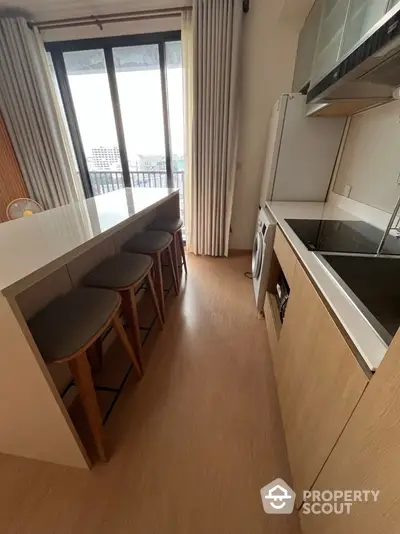 Modern kitchen with island seating and appliances in a high-rise apartment