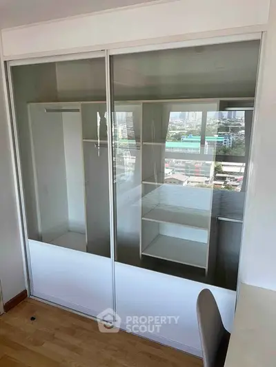 Modern bedroom with built-in mirrored wardrobe and city view