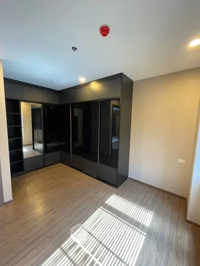 Spacious bedroom with modern built-in wardrobes and elegant wooden flooring