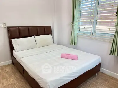 Cozy bedroom with modern bed and window view, perfect for relaxation.