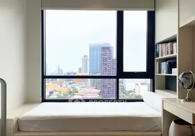 Modern bedroom with large window offering stunning city view and built-in bookshelf.