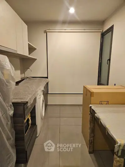Modern kitchen with sleek cabinetry and washing machine, featuring a minimalist design.