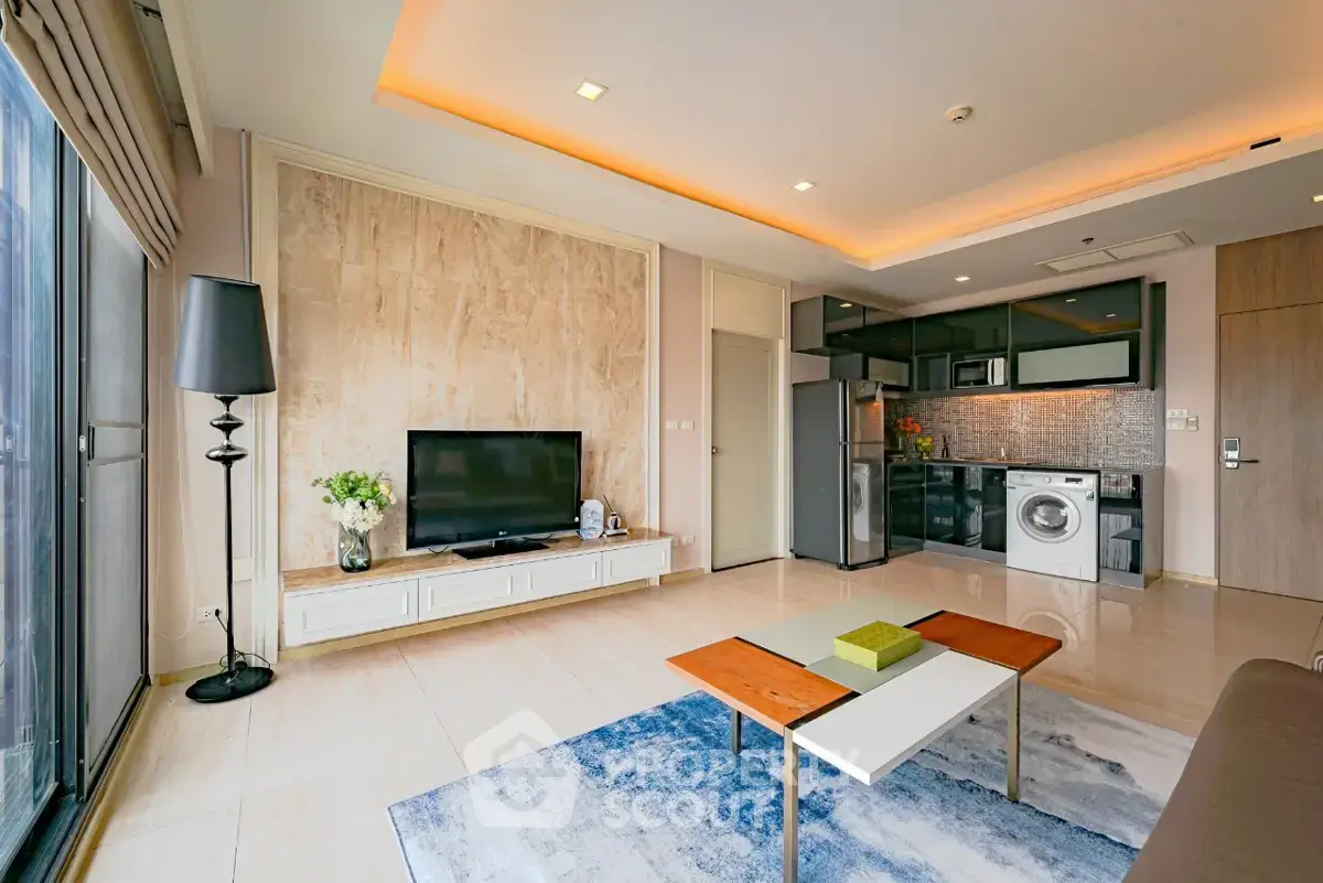 Modern living room with open kitchen, featuring sleek appliances and stylish decor.