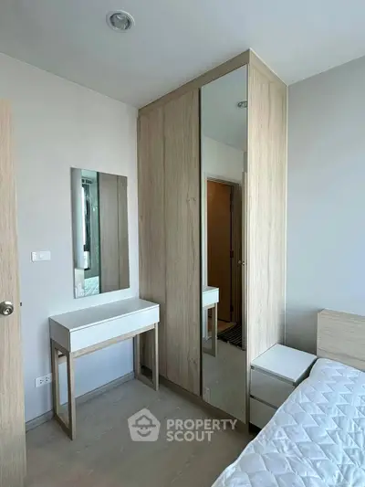 Modern bedroom with sleek wardrobe and stylish vanity in a cozy apartment.