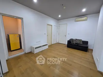 Spacious living room with wooden flooring and modern air conditioning unit