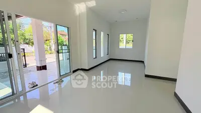 Spacious and bright living room with large windows and sliding glass doors opening to a patio.
