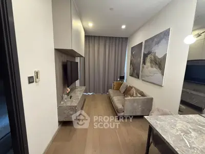 Modern living room with elegant decor and wall-mounted TV in a stylish apartment.