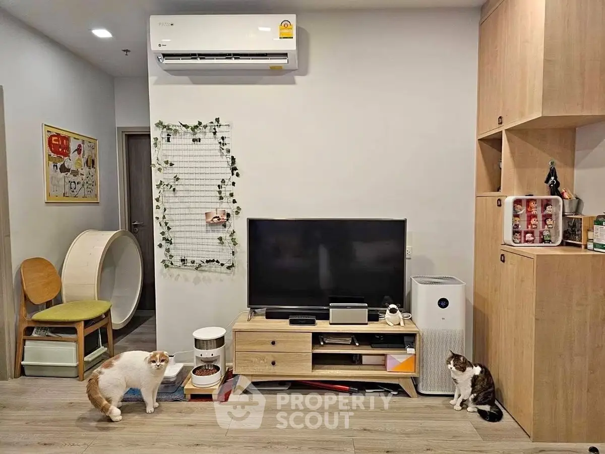 Cozy living room with modern decor, featuring a TV, air conditioner, and stylish wooden furniture.