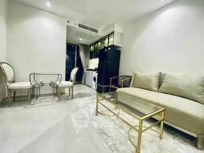 Elegant living room with modern furniture and open kitchen layout in a stylish apartment.