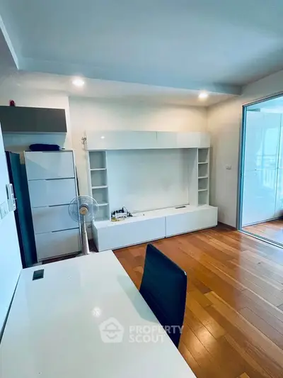 Modern study room with sleek white furniture and wooden flooring, perfect for productivity.
